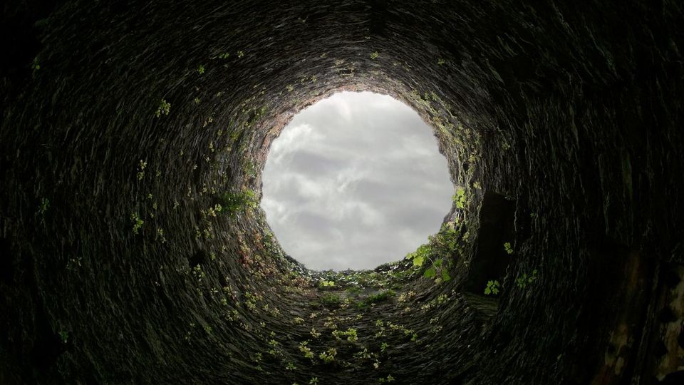 Looking through a well, up at the sky.