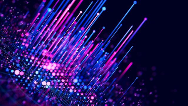 Columns of blue and pink light, emitted from a board of data-like signals. 