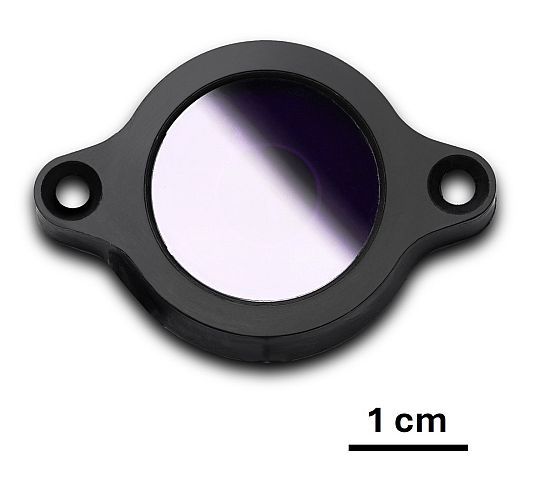 Figure 1: Photo of the UV chip. A round black frame with clear center and a scale showing 1 cm in relation to the UV chip depicted.