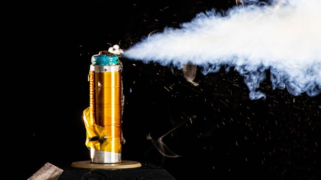 A golden battery that is failing, shooting a jet of smoke out to its right-hand side. 